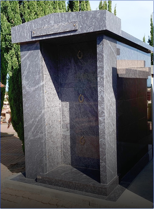 Mausolée moderne en marbre dans un cimetière.