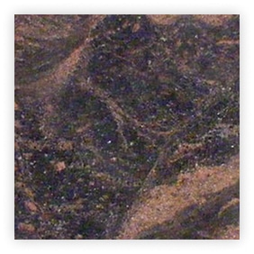 Texture de pierre sombre avec des veines colorées.