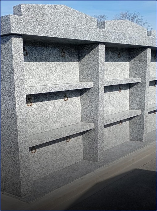 Columbarium en pierre grise avec niches.