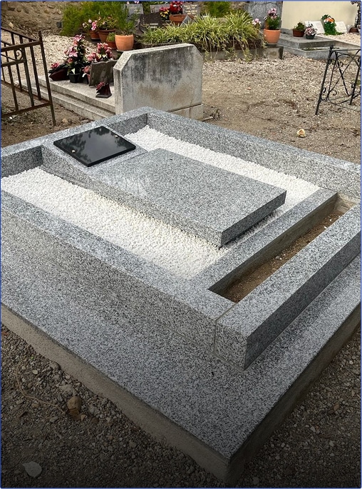 Tombe en granit avec gravier blanc.