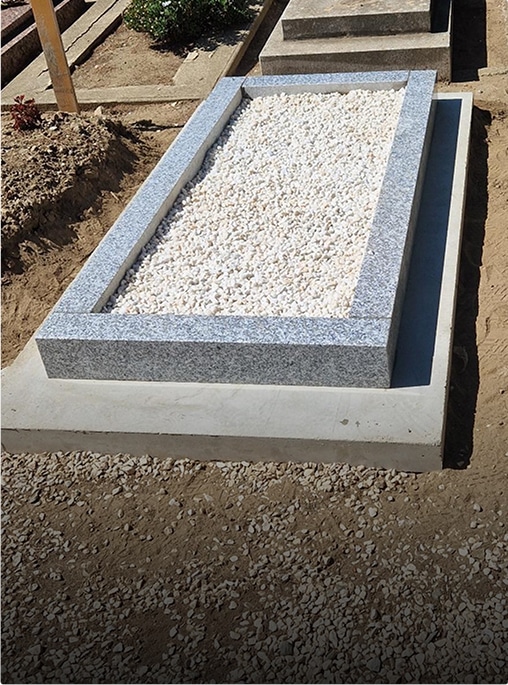 Cercueil en granit avec gravier blanc.