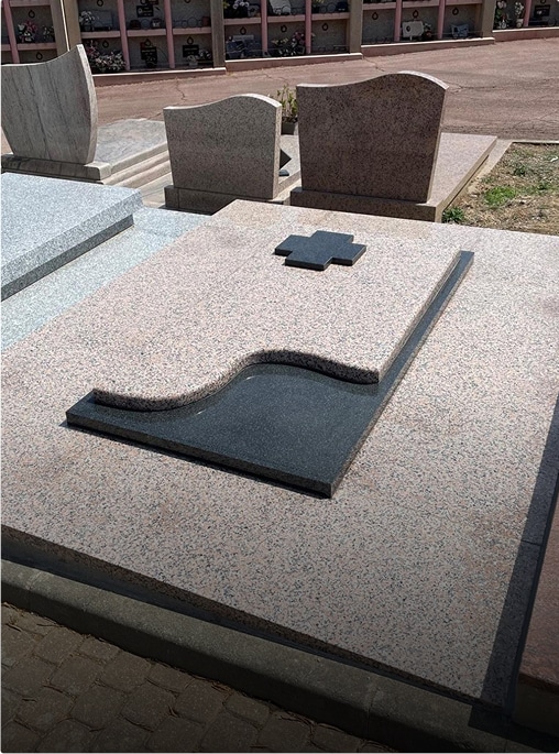 Tombe en granit avec croix et motif ondulé