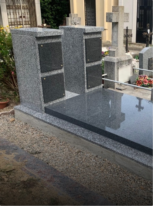 Tombe en granit gris dans un cimetière.