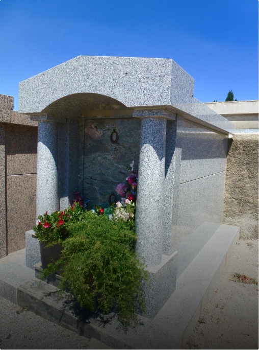 Tombe avec fleurs et décorations à l'extérieur.